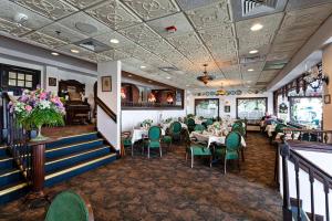 Boardwalk Plaza Hotel في شاطئ ريهوبوث: غرفة طعام مع طاولات وكراسي خضراء