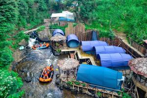 Pengalongan的住宿－Camping hutan pinus singkur rahong，一群人急速漂流在河里