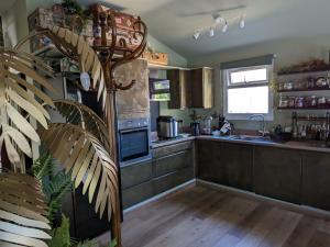 a kitchen with a sink and a stove top oven at Tulana Taggs - floating home on island idyll in Hampton Hill