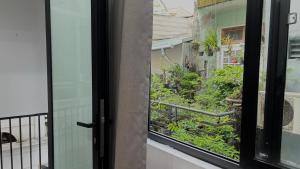 una finestra con vista sul giardino di Our Homestay in Hue - SELF CHECKIN a Hue