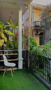 una silla blanca sentada en un balcón con plantas en Our Homestay in Hue - SELF CHECKIN, en Hue
