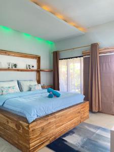 een slaapkamer met een groot houten bed met blauwe lakens bij Marta House gili air in Gili Air