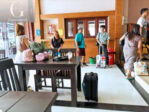 a group of people standing in a restaurant with luggage at Vang Vieng Central Hotel in Vang Vieng