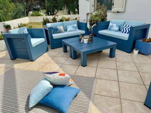 a patio with blue chairs and a table and pillows at TaliaKà B & B in Lipari