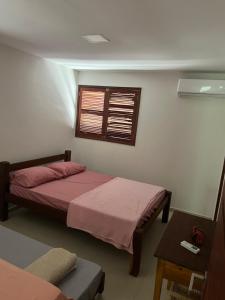 a bedroom with two beds and a window at Refúgio em Carneiros in Tamandaré
