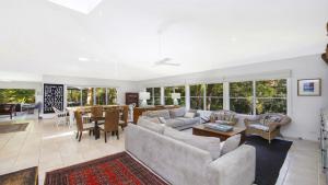 a living room with couches and a dining room at Your Beach House in Pearl Beach