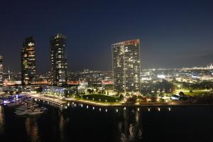 a night view of a city with tall buildings at Infinity Lux Apartment in Melbourne