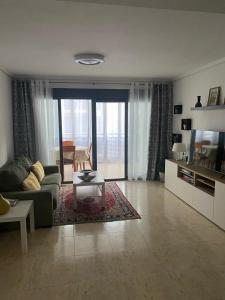 ein Wohnzimmer mit Sofa und Tisch in der Unterkunft Precioso apartamento con vistas al mar in Benicàssim