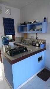 a kitchen with a stove and a blue counter top at Merpati - Studios in Sanur