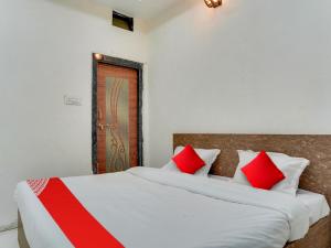 a bedroom with two beds with red and white pillows at OYO Hotel Shivansh in Bhopal