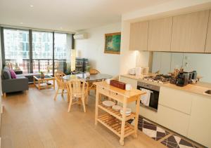 a kitchen and living room with a table and chairs at Infinity Lux Apartment in Melbourne