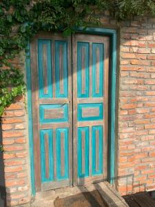 una puerta azul en el lateral de un edificio de ladrillo en TRANQUIL Tropical Hideaway en Kaduwela