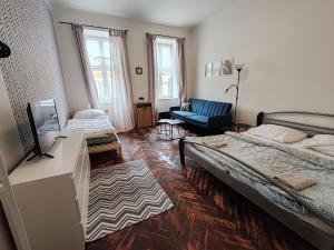 a bedroom with a large bed and a couch at Apartmán Hybešova2 in Brno