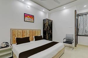 a bedroom with a large bed and a chair at OYO Flagship THE VINDH in Gorakhpur