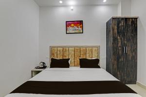 a bedroom with a large bed with a wooden headboard at OYO Flagship THE VINDH in Gorakhpur