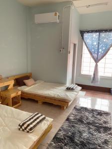 una habitación con dos camas y una ventana en CTM.INN (SISAKET)THAILAND, en Ban Bua Toei