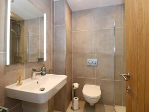 Un baño con lavabo, inodoro y espejo. en The Sanctuary, en Windermere 20 fotos más