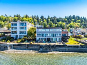 a large house on the shore of a body of water at Seaside Serenity 1 BR Apt with balcony near Alki in Seattle