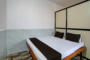 1 cama con 2 almohadas en una habitación en OYO Madhupushpa Farm House, en Rāmtek