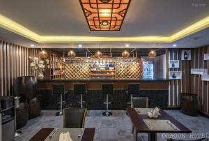 un ristorante con bar con tavoli e sedie di Golden Dragon Hotel Sài Gòn ad Ho Chi Minh