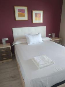 a bedroom with a large white bed with two night stands at Desconexión y Relax in Mareny Blau +18 photos