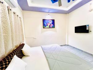 a room with a bed and a tv on the wall at Kailashbhavan Oasis - Full Villa By AP Villas in Ujjain