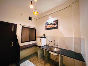 a bathroom with a sink and a microwave at Kailashbhavan Oasis - Full Villa By AP Villas in Ujjain
