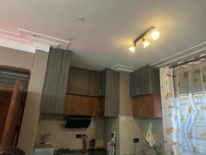 une cuisine avec des armoires en bois au plafond dans l'établissement Luxurious Apartments (Free Wifi Dstv & Long Stay Discounts), à Kampala
