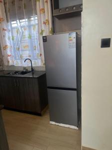 un réfrigérateur blanc dans une cuisine avec un comptoir dans l'établissement Luxurious Apartments (Free Wifi Dstv & Long Stay Discounts), à Kampala 22 autres photos