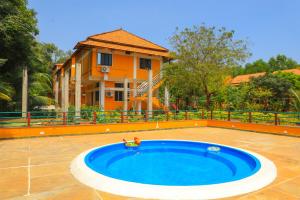 a swimming pool in front of a house at Auro Wellness Castle in Puducherry