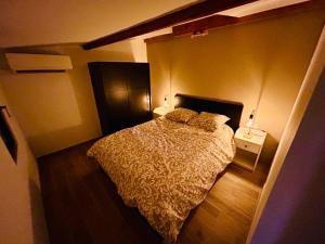 een slaapkamer met een bed in een kleine kamer bij Gîte indépendant en centre-ville in LʼIsle-sur-la-Sorgue