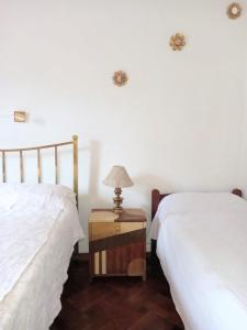 1 dormitorio con 2 camas y mesa con lámpara en Departamento 3 habitaciones en Salta