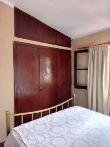 Un dormitorio con un gran armario de madera y una cama en Departamento 3 habitaciones en Salta