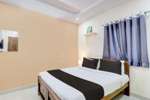Super Collection O Sri Balaji Luxury rooms في حيدر أباد: غرفة نوم بسرير وستارة زرقاء