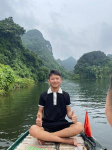 Ein Mann, der auf einem Boot auf einem Fluss sitzt. in der Unterkunft People's House Sea View O Giang in Noi Bai