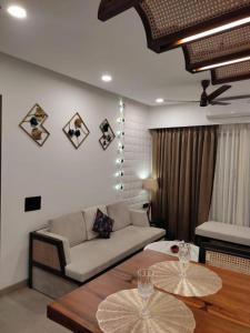 uma sala de estar com um sofá e uma mesa em Kudrat Paradise - Full Villa By AP Villas em Indore