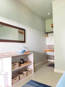 Habitación con encimera con estanterías y espejo en Marta House gili air, en Gili Air