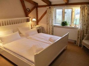een groot wit bed in een kamer met een raam bij Countryside holiday home near bus stop in Hattlund