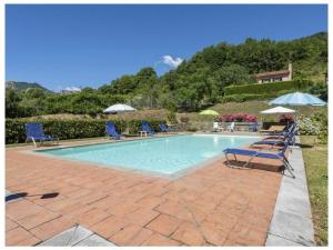 una piscina con sillas y sombrillas en un patio en Villa Popiglio, en San Marcello Pistoiese