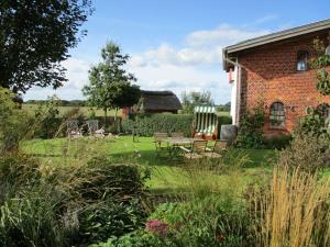 een tuin met een tafel en stoelen en een gebouw bij Countryside holiday home near bus stop in Hattlund