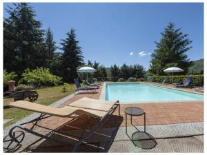 una piscina con sillas y sombrillas junto a ella en Villa Popiglio, en San Marcello Pistoiese