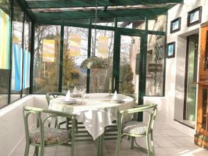 a dining room with a white table and chairs at Dans les Bois in Taintrux