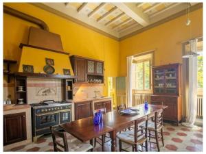 cocina con mesa de madera y fogones horno superior en Villa Rignano Comfortable holiday residence, en Rignano sullʼArno