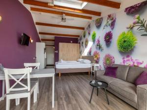 ein Wohnzimmer mit einem Sofa und einem Bett in der Unterkunft Appealing studio with garden in Koudekerke