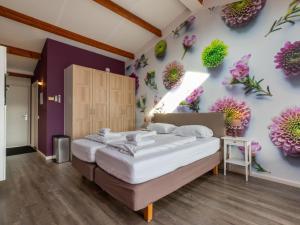 ein Schlafzimmer mit einem Bett mit Blumen an der Wand in der Unterkunft Appealing studio with garden in Koudekerke