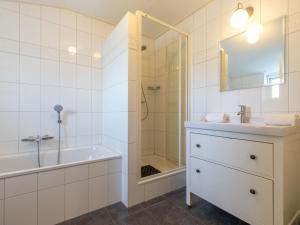 ein Bad mit einer Badewanne, einem Waschbecken und einer Dusche in der Unterkunft Appealing studio with garden in Koudekerke