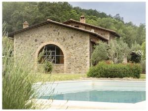 une maison en pierre avec une piscine en face de celle-ci dans l'établissement Villa Betta Comfortable holiday residence, à Città di Castello