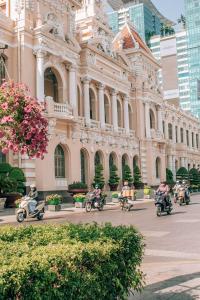 a group of people riding motorcycles in front of a building at Walhalla Hotel Saigon in Ho Chi Minh City