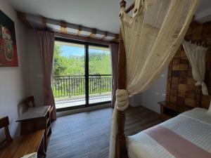 una camera con letto a baldacchino e ampia finestra di Wanzai B&B a Xiaoliuqiu