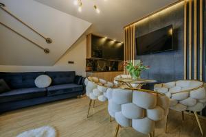 a living room with a couch and a table and chairs at Willa Zielone Wzgórze - Zakopane - Luksusowe apartamenty in Zakopane